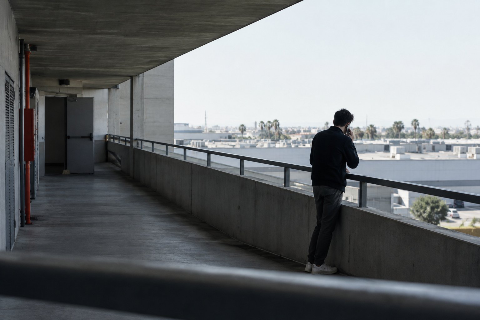 Valencia: someone standing at the railing of a covered walkway, looking out over the city.